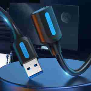 Vention CBHBI USB 3.0 extension cable showing male Type-A connector plugged into a laptop Close-up of gold-plated USB-A male and female connectors on the Vention cable Coiled 3 m black USB 3.0 extension cable with dual ferrite cores visible under PVC jacket Vention extension cable connecting an external hard drive to a desktop PC Side view of USB 3.0 cable highlighting sturdy PVC outer jacket and braided shielding Vention CBHBI cable laid out straight on a desk with a keyboard and mouse attached