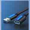 Vention CBHBG USB 3.0 extension cable with male and female Type-A connectors on a white background Close-up of the gold-plated USB 3.0 Type-A male plug and PVC-jacketed cable Female USB-A port of the Vention extension cable connected to an external hard drive Full 1.5 m length of the Vention CBHBG cable coiled neatly on a desk next to a laptop Dual ferrite cores visible under the PVC jacket near the male connector end Vention cable in use, extending a keyboard’s USB connection to a desktop PC