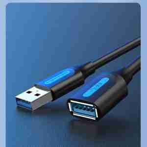 Vention CBHBG USB 3.0 extension cable with male and female Type-A connectors on a white background Close-up of the gold-plated USB 3.0 Type-A male plug and PVC-jacketed cable Female USB-A port of the Vention extension cable connected to an external hard drive Full 1.5 m length of the Vention CBHBG cable coiled neatly on a desk next to a laptop Dual ferrite cores visible under the PVC jacket near the male connector end Vention cable in use, extending a keyboard’s USB connection to a desktop PC