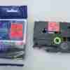 Compatible Brother TZ2-431 12mm black on red label tape roll Brother P-touch printer with TZ2-431 tape installed Black on red label applied to toolbox or safety folder Close-up of printed label on red laminated tape TZ2-431 label used for cable tagging Packaging of compatible red label tape for Brother printers