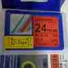 Compatible Brother TZ2-451 24mm label tape black on red roll Brother label printer with red tape installed Warning label printed with TZ2-451 red laminated tape Durable black on red label applied to electrical panel Roll of compatible 24mm TZe label tape in red TZ2-451 label cartridge close-up with eco