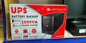 Front-facing Lightwave LW 2000VA UPS with LED panel Side-angle view showing air vents and design Rear view with 3‑pin socket output UPS powering a PC, monitor, and router setup LED indicators lit during battery operation Close-up of audible alarm speaker and status LEDs
